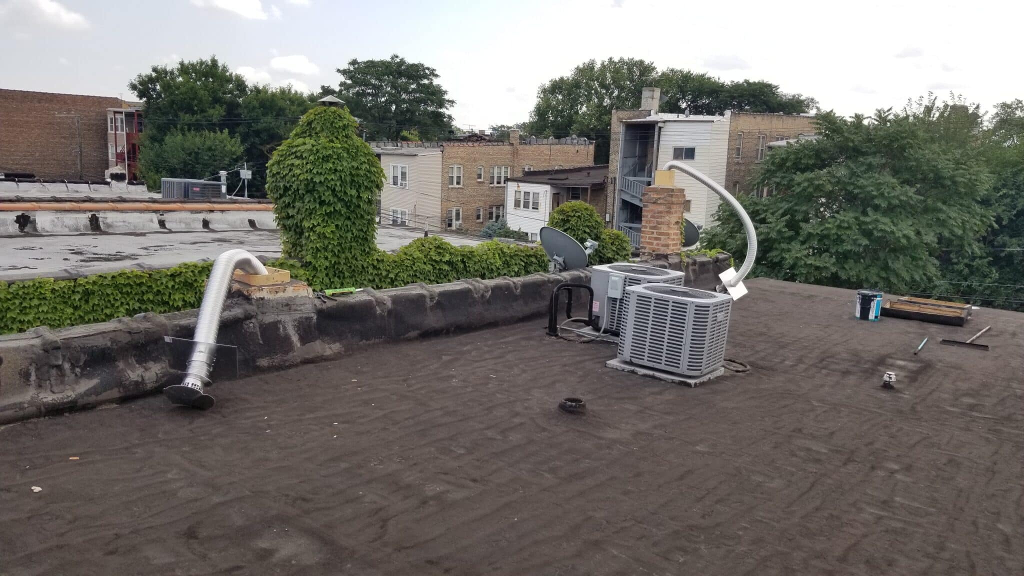 Rooftop with AC units and vent pipe.